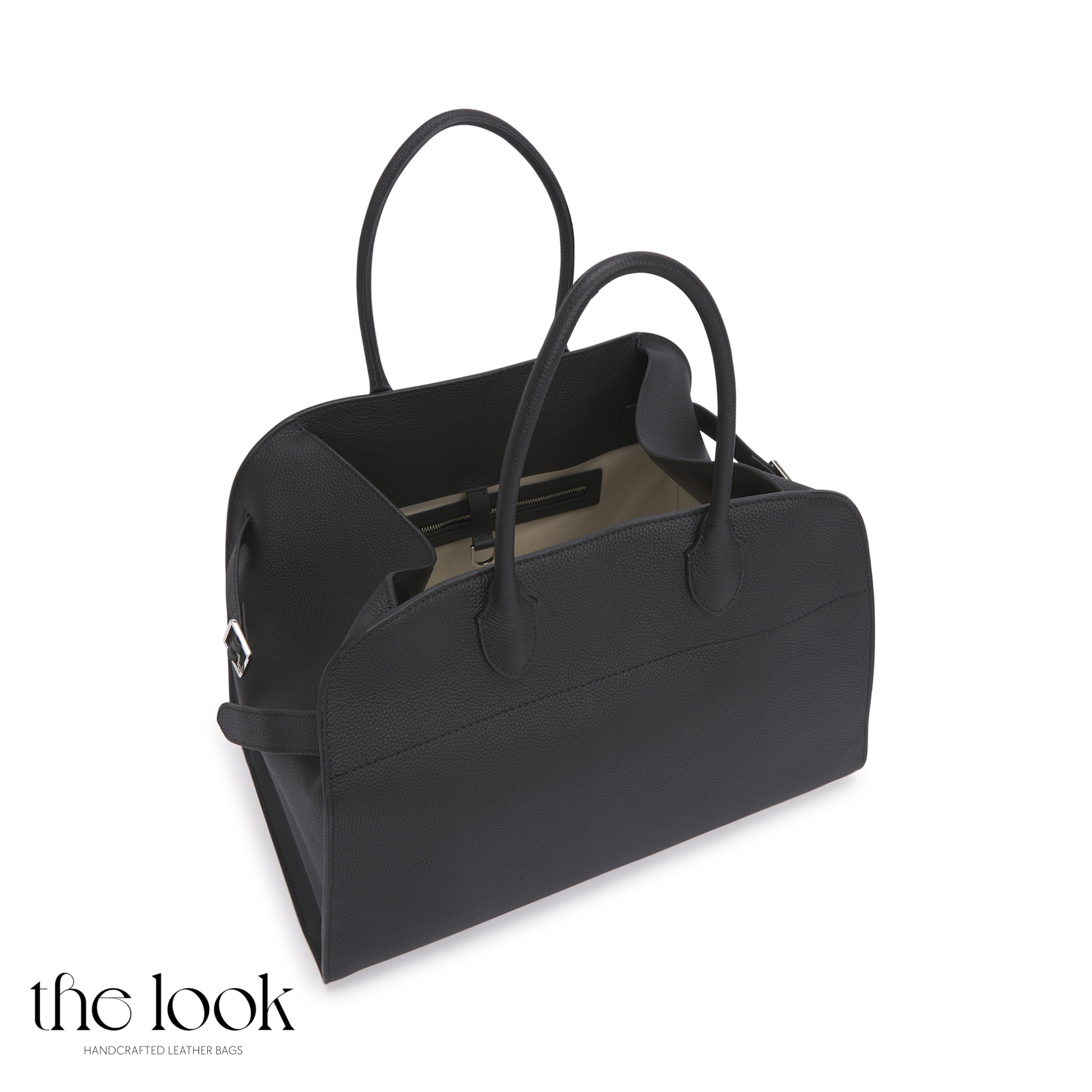 Black handbag with reflective surface on a white background, branded 'the look'. | The Look Officiel