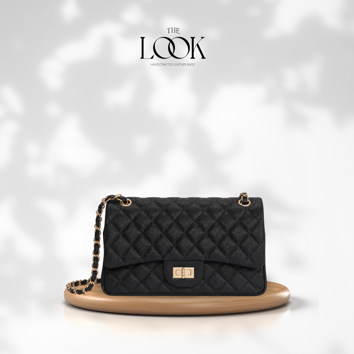 The Quilte Medium Convertible Shoulder Bag in Black, caviar calfskin leather with champagne gold hardware, front view | The Look Officiel