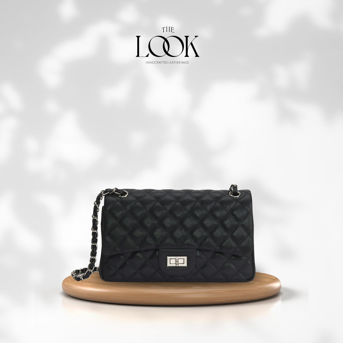 The Quilte Medium Convertible Shoulder Bag in black caviar calfskin leather with silver hardware, front view | The Look Officiel