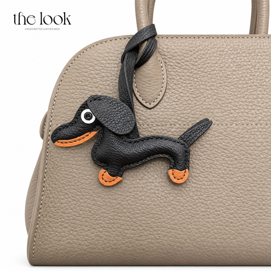 Smokey the Black Dachshund dog bag charm styled on a taupe handbag | The Look Officiel