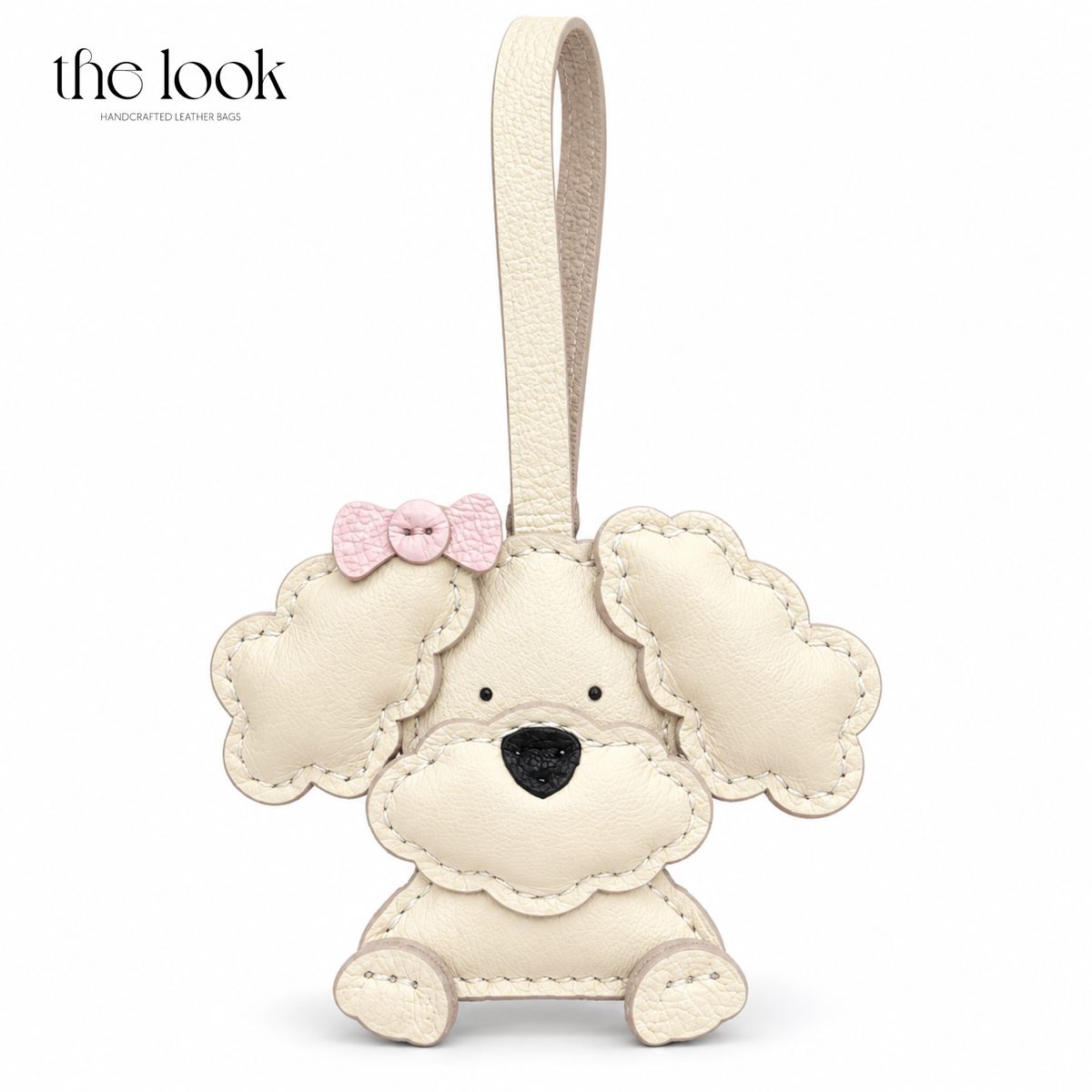 Lulu the Cream Poodle cream dog bag charm with pink bow detail | The Look Officiel