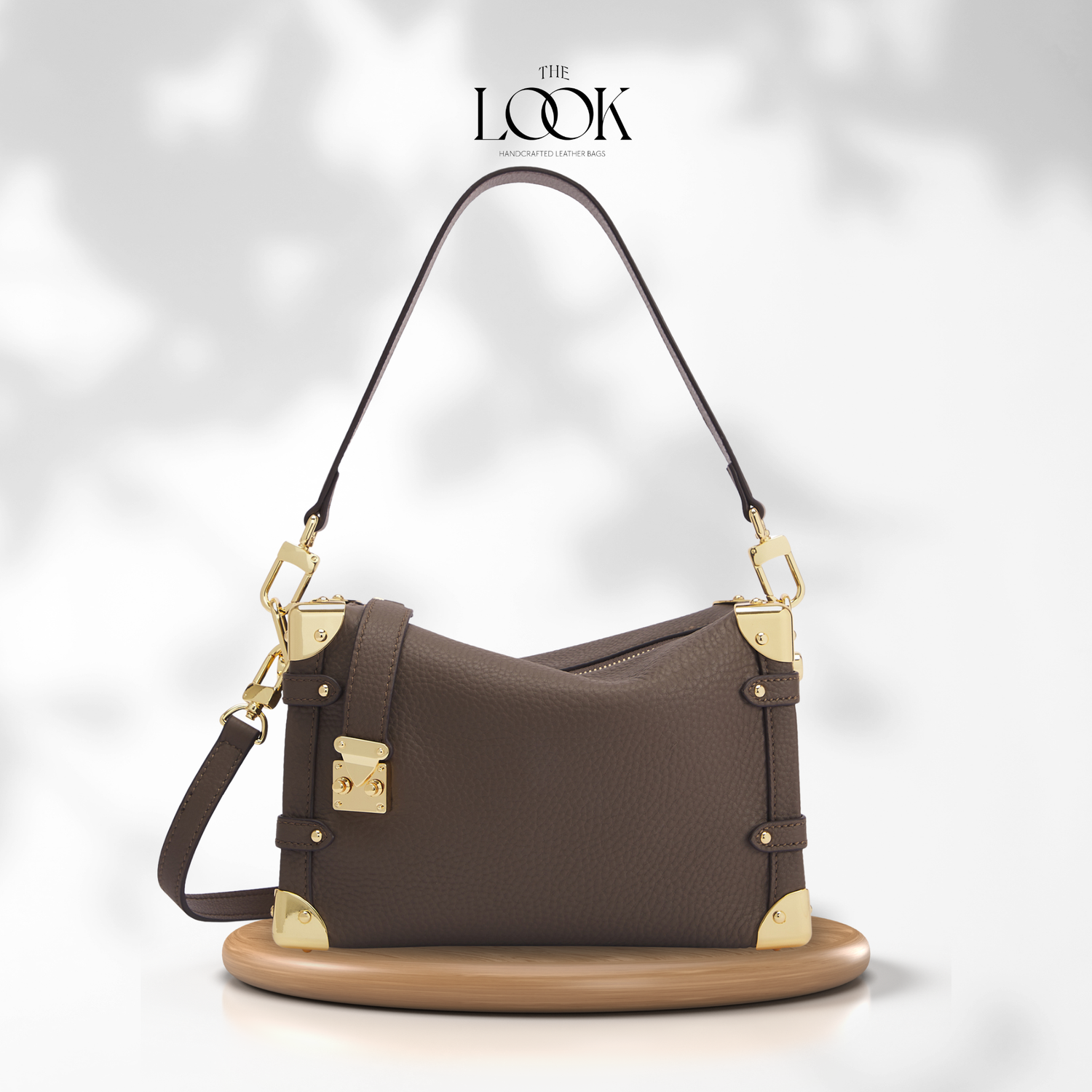 Brown handbag with gold accents on a white background, featuring 'The Look' brand. | The Look Officiel