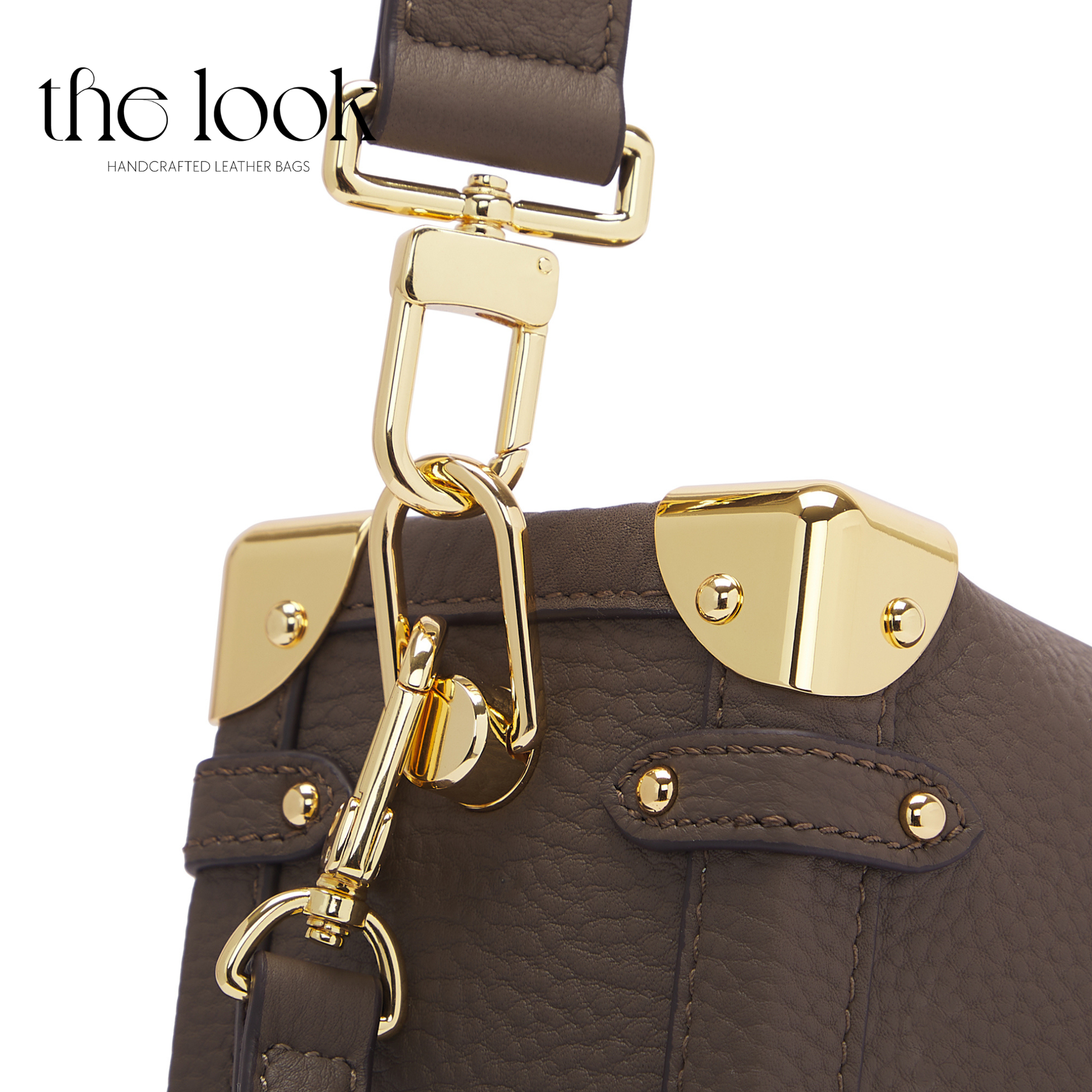 Brown leather handbag with gold hardware on a white background. | The Look Officiel