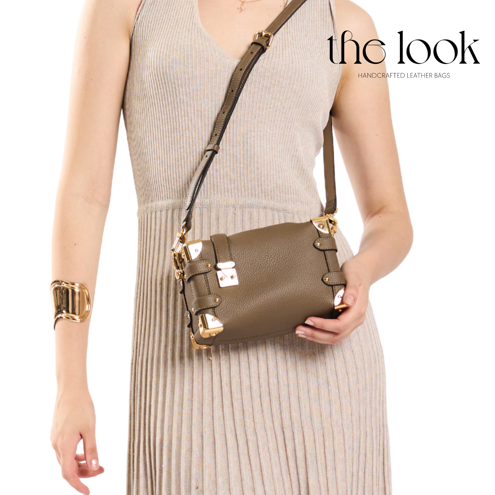 Woman holding a brown leather handbag with gold accents, wearing a beige dress and gold bracelet, on a white background with 'the look' branding. | The Look Officiel