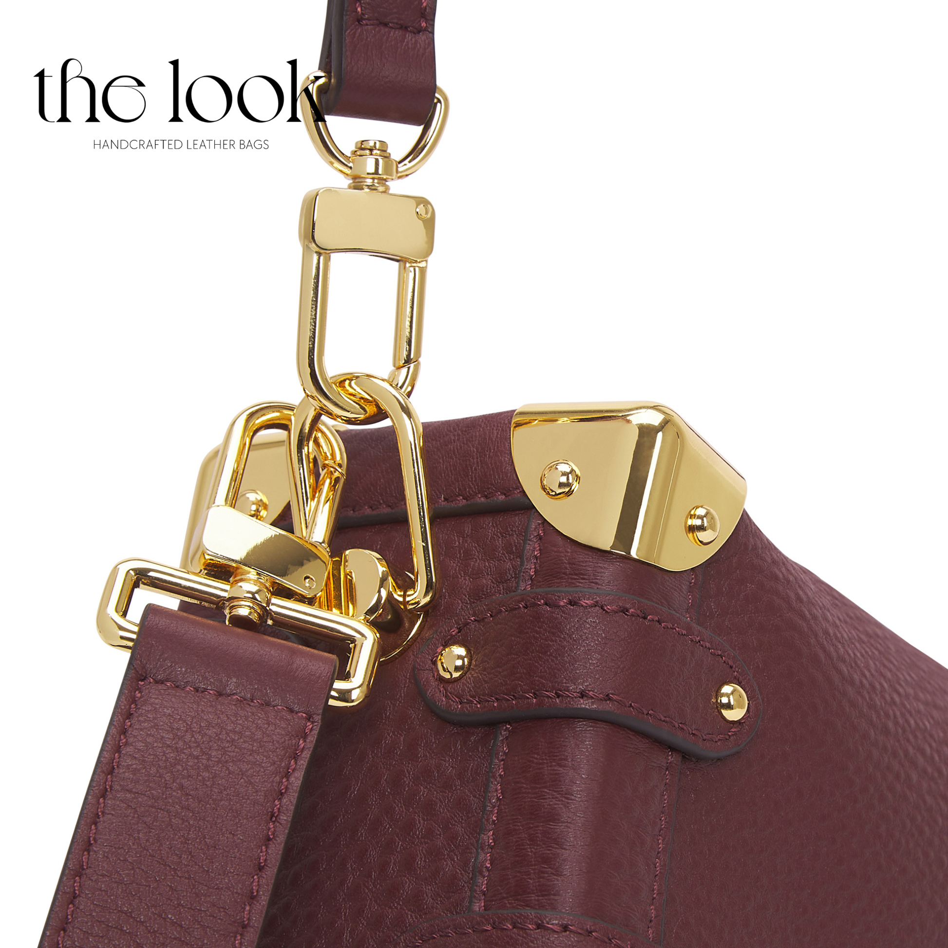 Close-up of a maroon leather handbag with gold hardware on a white background, featuring 'the look' brand. | The Look Officiel