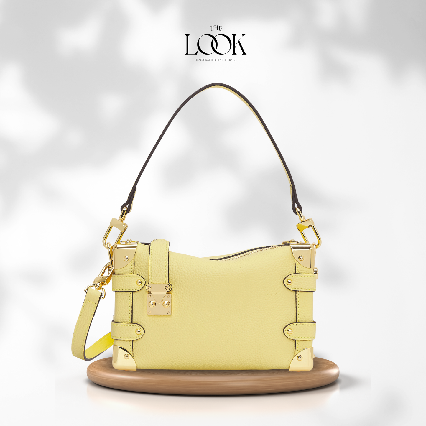 Yellow handbag with gold accents on a white background, featuring 'The Look' brand. | The Look Officiel