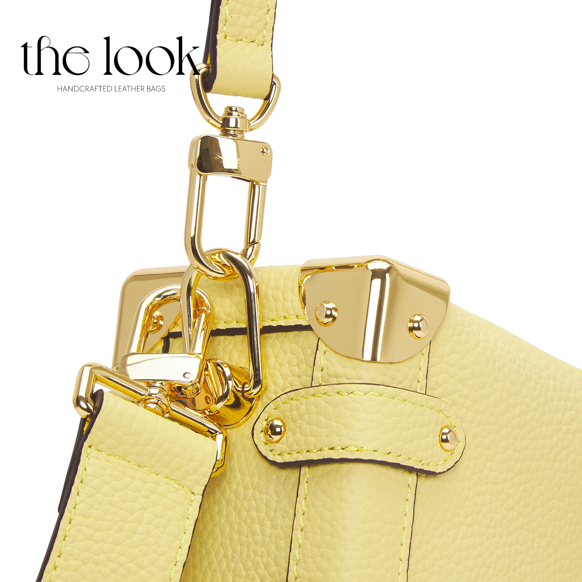 Close-up of a yellow leather handbag with gold hardware on a white background, featuring 'the look' brand. | The Look Officiel