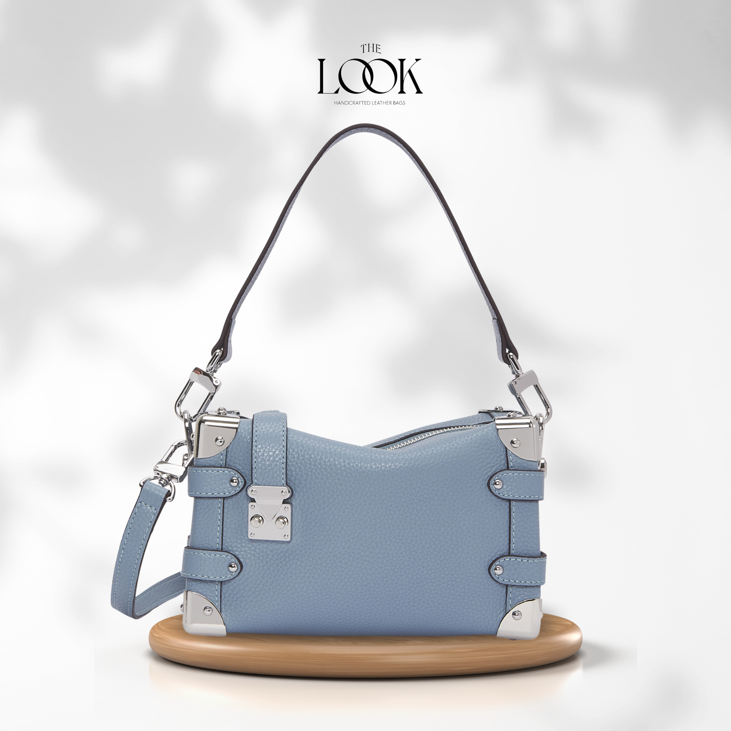 Blue handbag with silver accents on a white background, featuring 'The Look' branding. | The Look Officiel