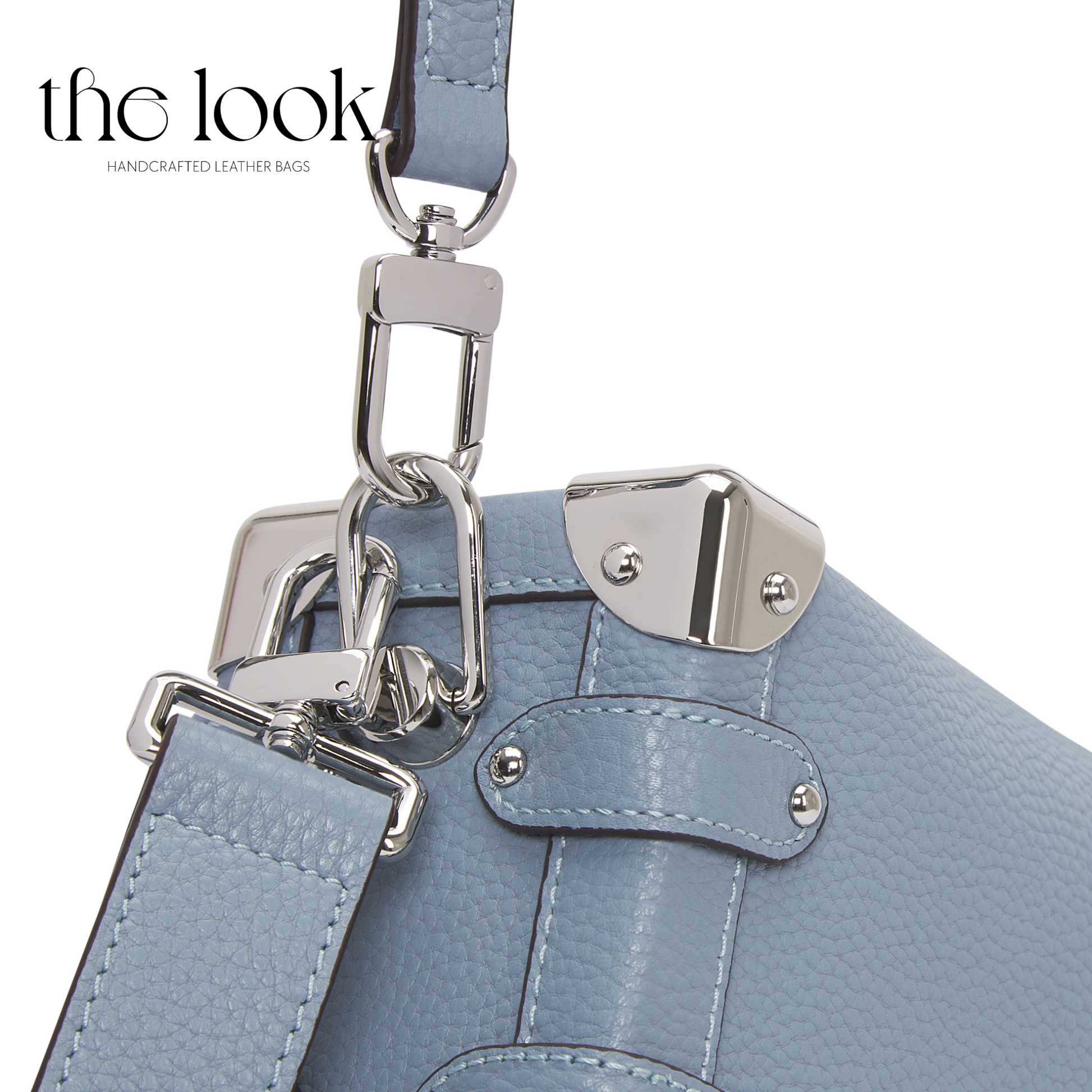 Close-up of a light blue leather handbag with silver hardware on a white background, featuring 'the look' brand. | The Look Officiel