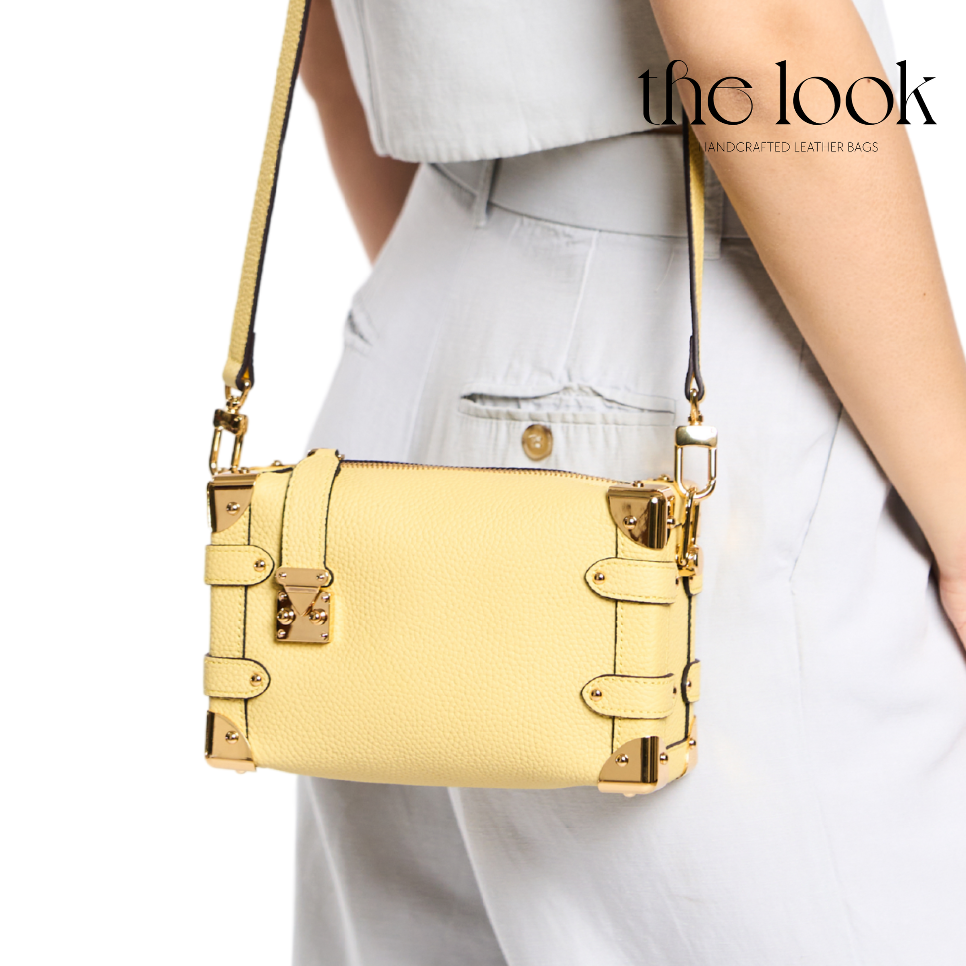 Yellow handbag with gold accents worn by a person, branded 'the look'. | The Look Officiel