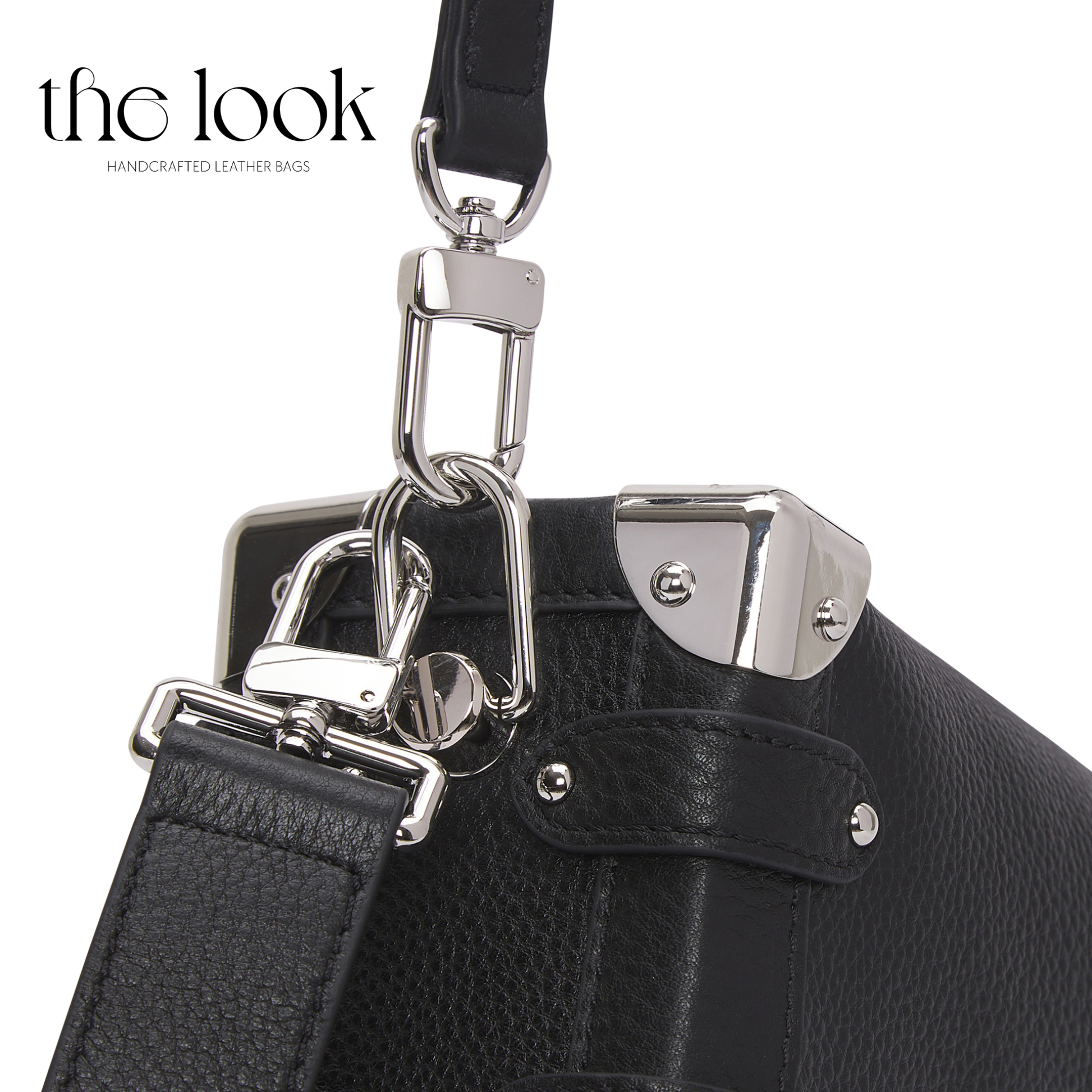 Close-up of a black leather bag with silver hardware on a white background, featuring 'the look' brand. | The Look Officiel