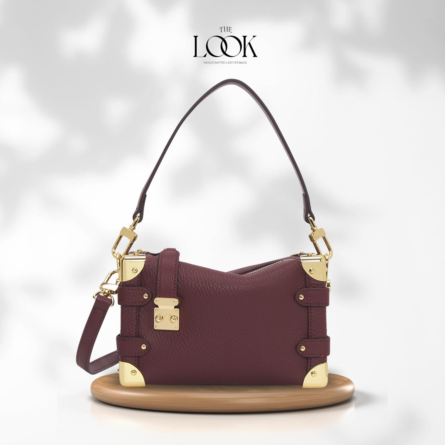 Maroon handbag with gold accents on a white background, featuring 'The Look' brand. | The Look Officiel