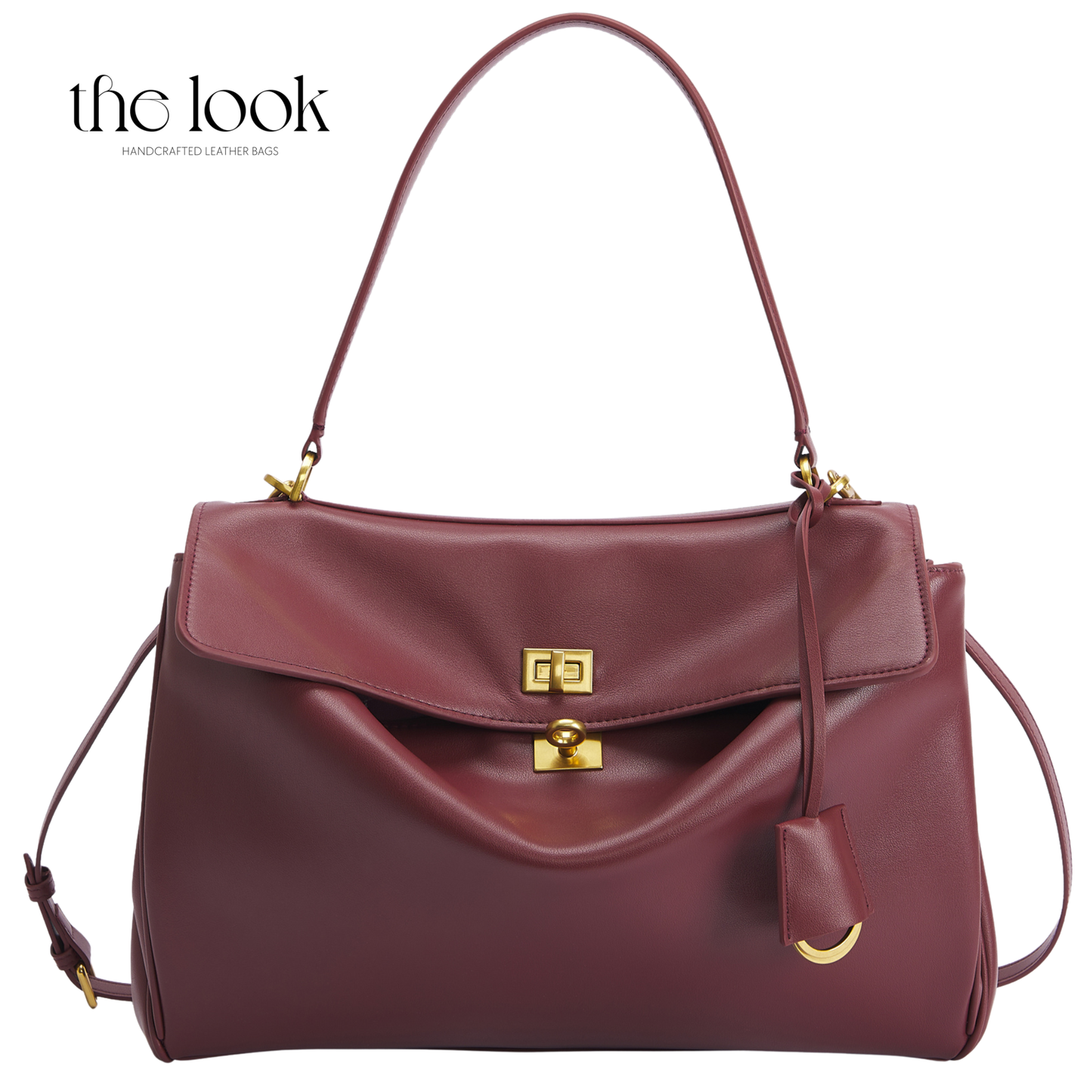 A burgundy leather handbag with gold-tone hardware, featuring a top handle, a front flap with a lock closure, and a hanging leather tag