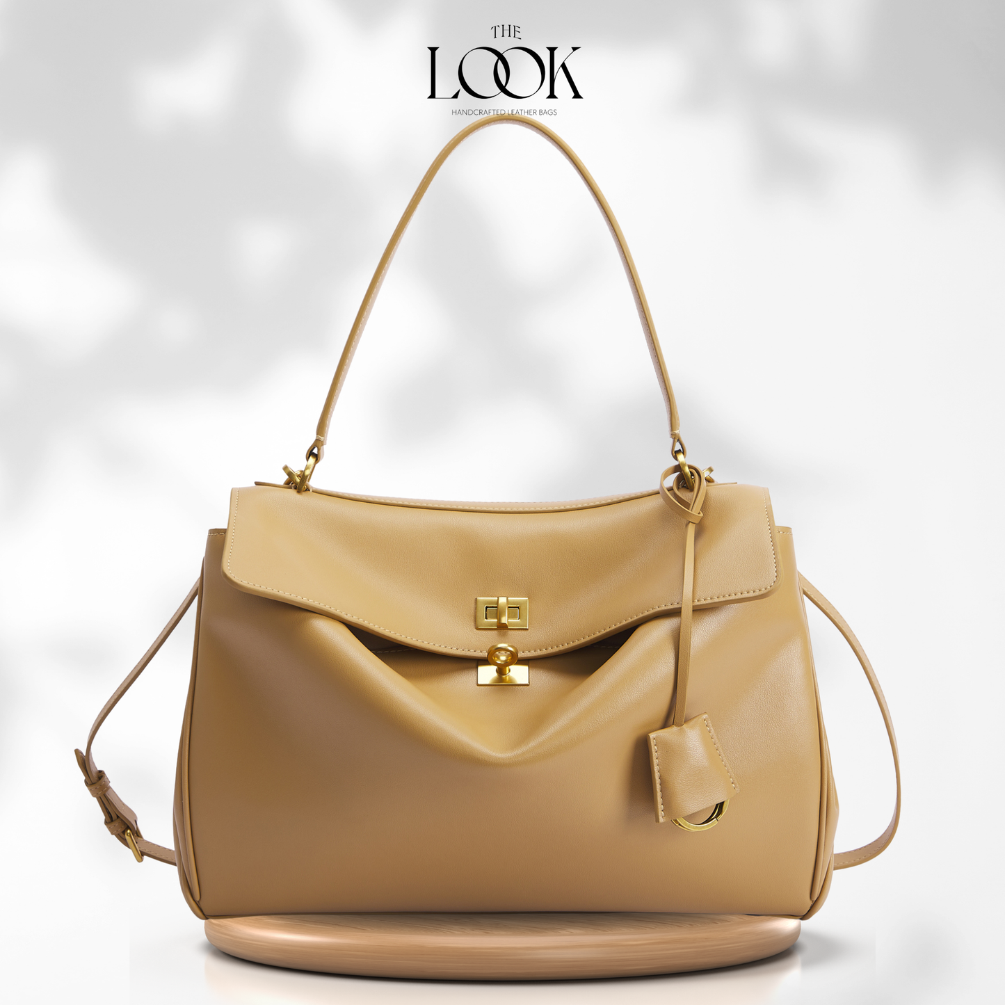 A tan leather Rodeo handbag with gold-tone hardware, featuring a top handle, a flap closure, and a detachable shoulder strap