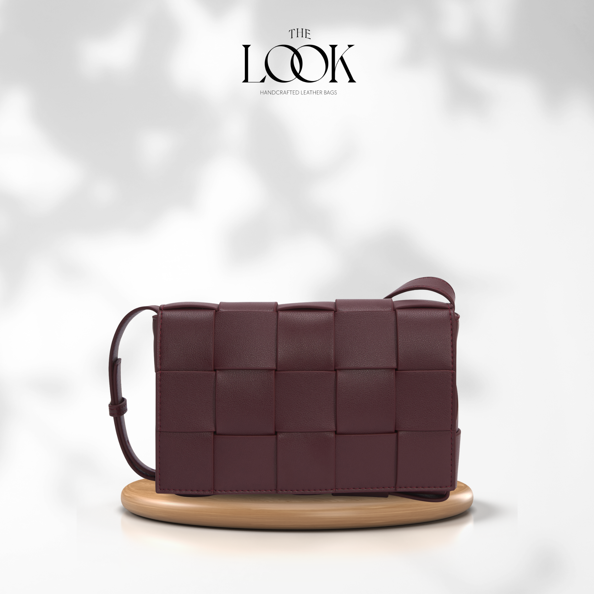 Woven leather handbag on a wooden stand with 'The Look' branding. | The Look Officiel